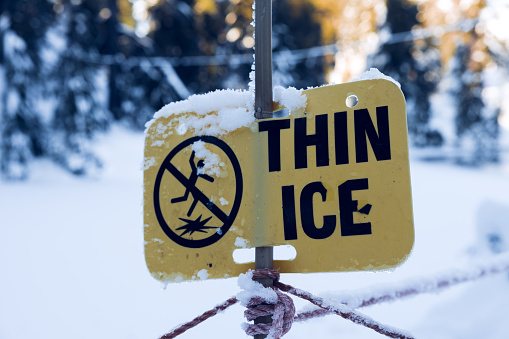 View of warning sign Thin Ice at the Blue Grouse Lake in British Columbia