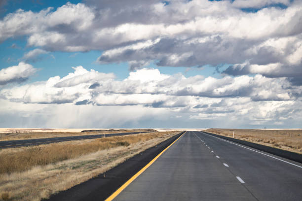 istock Wide road resting on the horizon with fields with neatly cut grass beckons forward tourists and travelers exploring new places and routes 1454292015