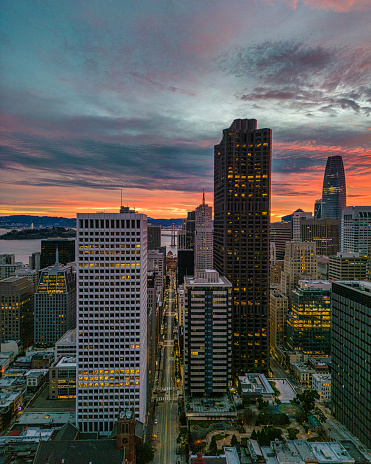 Aerial view over San Francisco with a burning sunrise over the Bay. Skyscrapers fill the skyline.