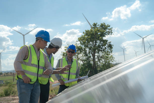 istock Asian engineer working in fieldwork outdoor. Workers check and inspect construction and machine around building project site. Wind turbine for electrical of clean energy and environment sustainable. 1454295854