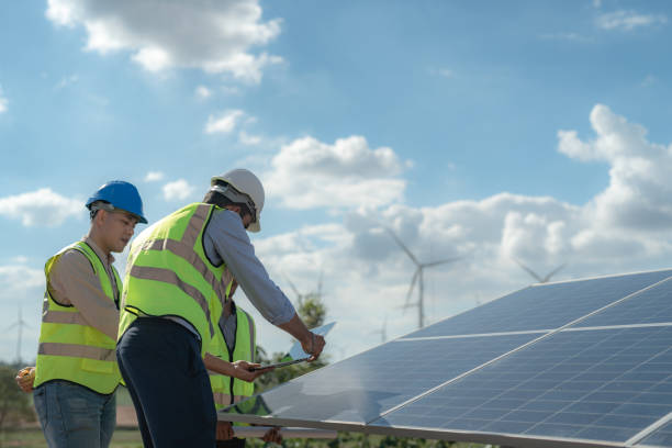 istock Asian engineer working in fieldwork outdoor. Workers check and inspect construction and machine around building project site. Wind turbine for electrical of clean energy and environment sustainable. 1454295893