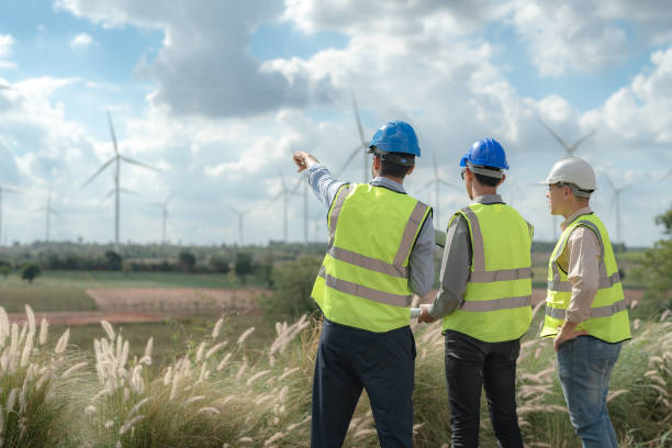 istock Asian engineer working in fieldwork outdoor. Workers check and inspect construction and machine around building project site. Wind turbine for electrical of clean energy and environment sustainable. 1454295927