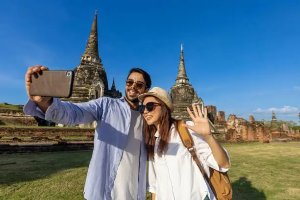 Couple of foreign tourists take selfie photo at Wat Phra Si Sanphet temple, Ayutthaya Thailand, for travel, vacation, holiday, honeymoon and tourism concept