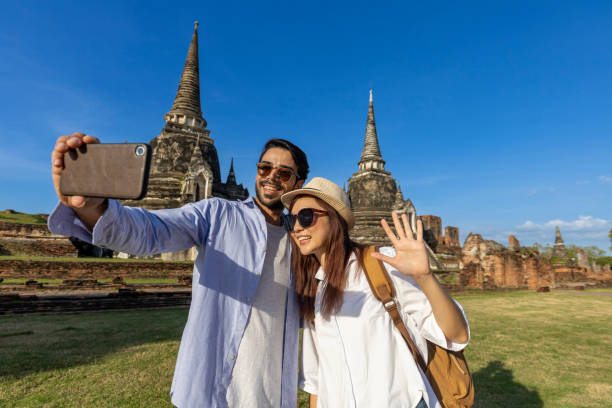 пара иностранных туристов делает селфи в храме wat phra si sanphet, аюттхая таиланд, для путешествий, отпуска, отдыха, медового месяца и туризма - wat blue ancient old стоковые фото и изображения