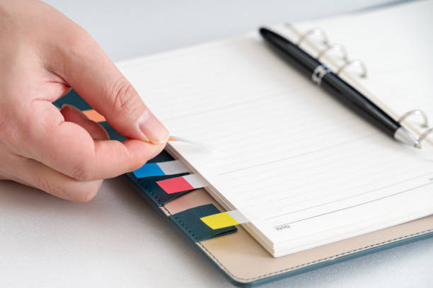 istock Hands of a businessman writing a schedule or recording ideas in a diary 1454297640