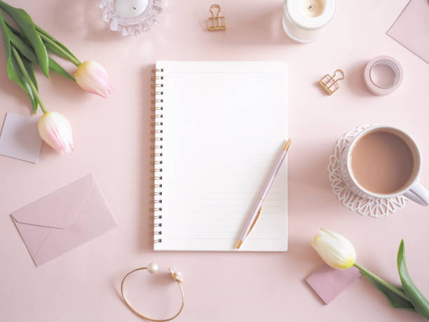 istock Cute desk image with notebook and flowers on pink background 1454301447