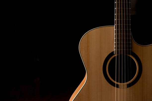 istock Classic Acoustic guitar close up, dramatically lit on a black background with copy space 1454303003