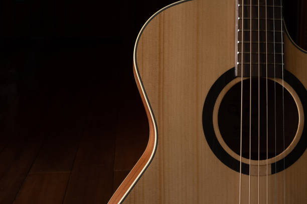 istock Classic Acoustic guitar close up, dramatically lit on a black background with copy space 1454303004