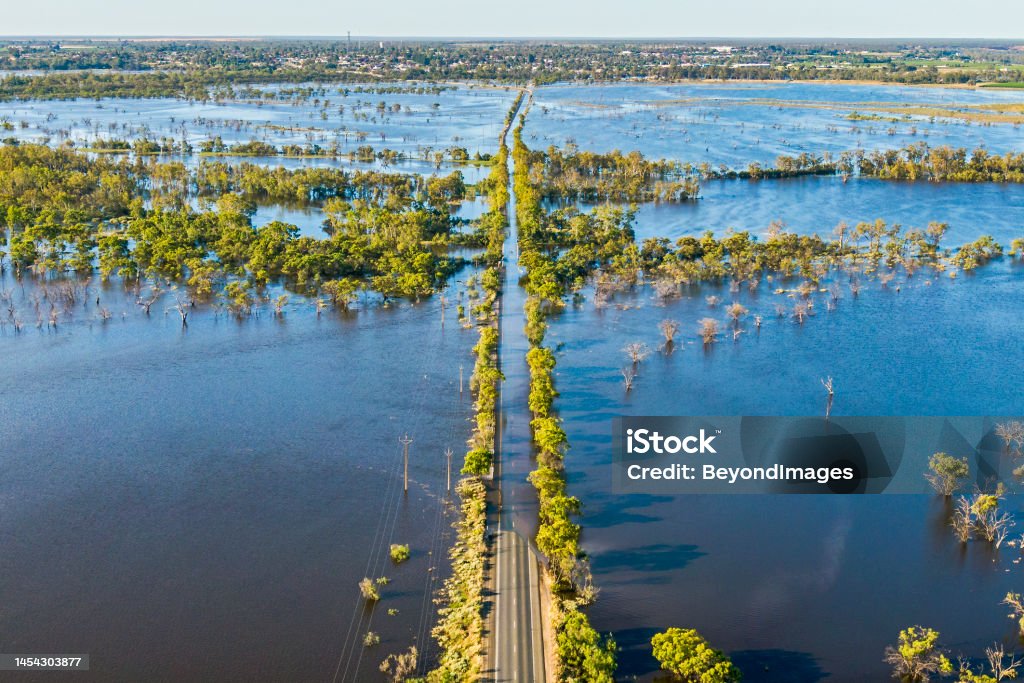 Aerial view flooded tree-lined major Riverland highway on River Murray in South Australia Aerial view flooded tree-lined Bookpurnong Road, the main Loxton to Berri connector road on River Murray in South Australia: flooded Gurra Gurra floodplain, bridge over Gurra Gurra Creek in centre frame, town of Berri in the distance on tree-covered hills, River Murray just visible in distance. Climate Change Stock Photo
