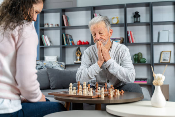 istock Dementia therapy in playful way.  senior elder man stay at nursing home, enjoy activity relation playing chess 1454314407