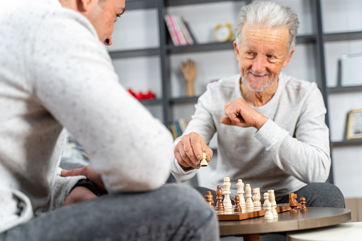 Dementia therapy in playful way. senior older man stay at nursing home, enjoy activity relation playing chess