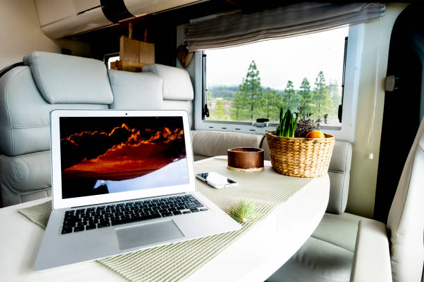 istock Alternative office and workstation for freedom smart working or digital nomad lifestyle concept. Laptop computer on a motor home table with nature and freedom view outside the window. Job activity 1454318359