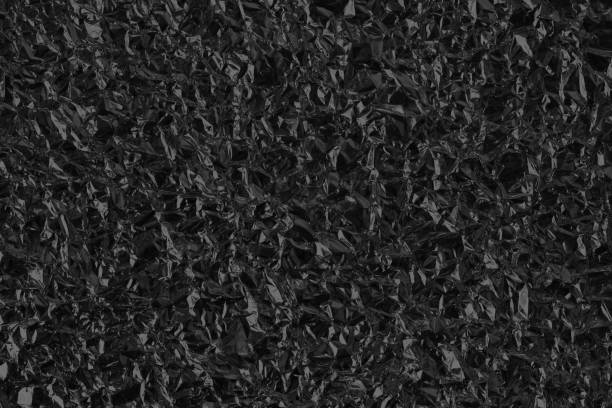 istock Shiny black foil texture background, pattern of wrapping paper with crumpled and wavy. 1454318770