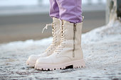 Woman winter boots on snow close-up photo of winter shoes. Blurred background. Selective focus