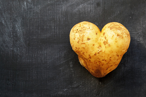 Potato in the shape of a heart on a black background