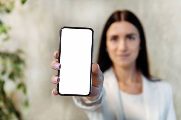 istock Businesswoman showing smartphone with blank screen 1454321856