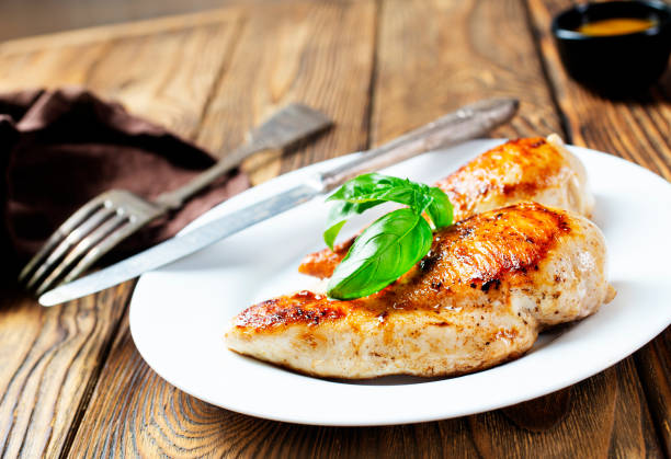 istock Marinated grilled healthy chicken breasts cooked on a summer BBQ and served with fresh herbs and lemon juice 1454324035