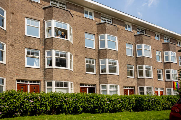 Amsterdam, Netherlands – June 20, 2021: Last century Dutch build type residential housing with greenery lane in front
