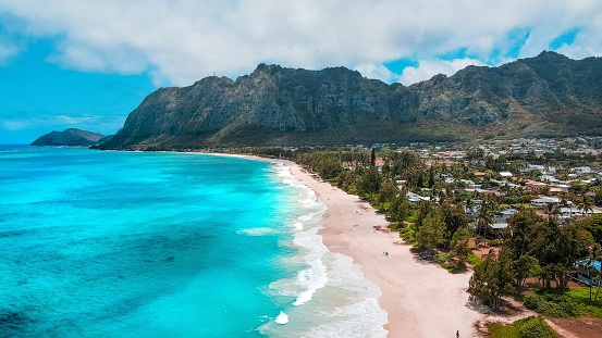The scenic Waimanalo beach with a turquoise seascape with foamy waves washing the shore in Hawaii