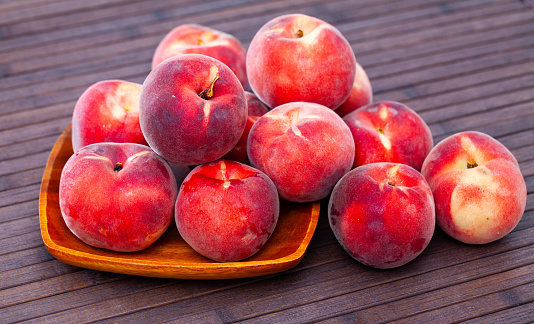 Closeup of whole ripe red peaches on wooden table. Vitamin fruits