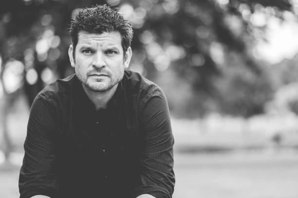 istock Closeup of a man sitting on a bench in a park 1454330655