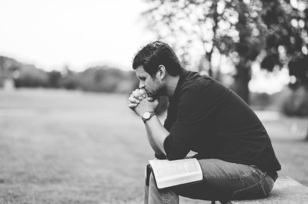 istock Closeup of a man sitting on a bench in a park 1454330671