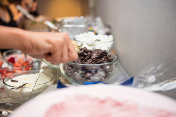 Guest taking crushed chocolate cookies from the dessert table bar A guest taking crushed chocolate cookies from the dessert table bar strawberry crush stock pictures, royalty-free photos & images
