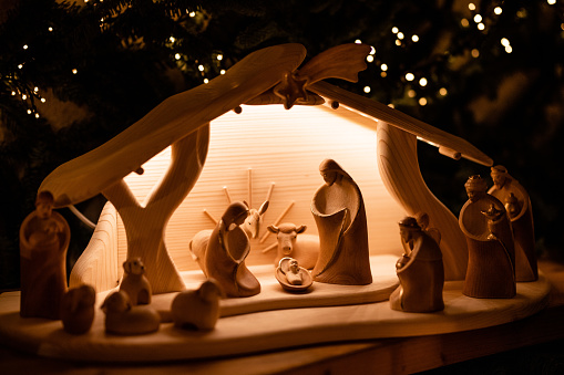 A cute young girl plays with a nativity set at home