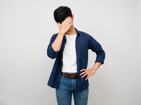 Asian man stand gesture close his face feels headache and depressed isolated