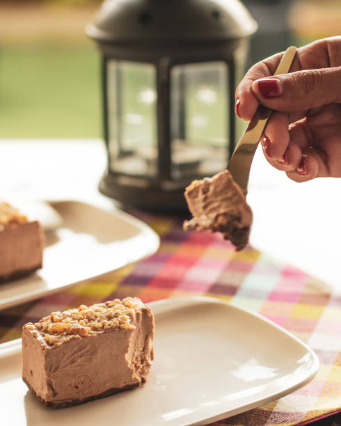 istock Woman's hand slicing a delicious chocolate cake with a silver fork 1454338200