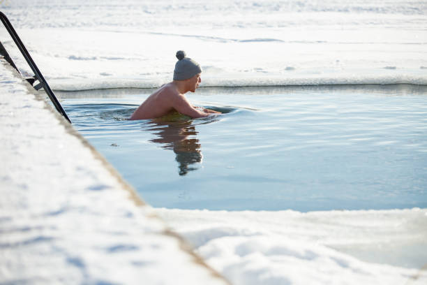 istock A man in warm hat swimming in an ice hole 1454339489