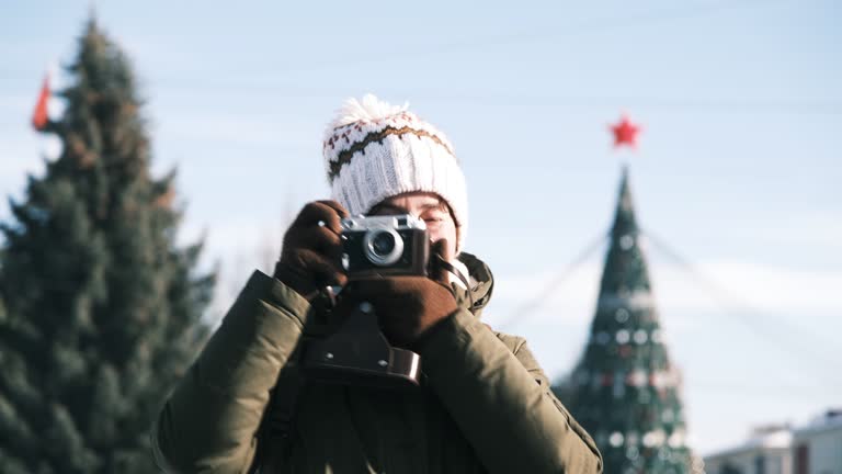 Female tourist is taking pictures on vintage film camera