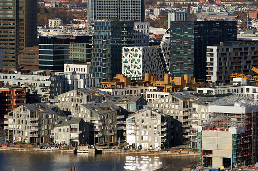 Os, Norway – October 31, 2021: A modern apartment buildings in Oslo downtown with new high office buildings in the background, Norway