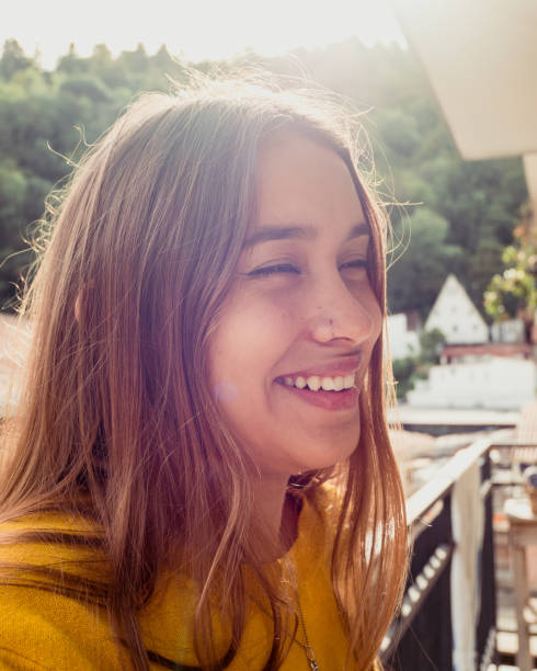 istock Attractive young girl  laughing on a balcony 1454343129