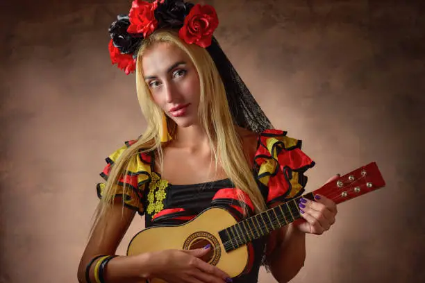 A gypsy woman wearing a traditional dress and playing charango