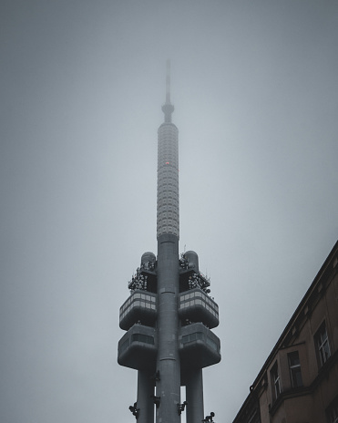 A scenic shot of a skyscraper top hidden in the fog in Prague, Czech Republic