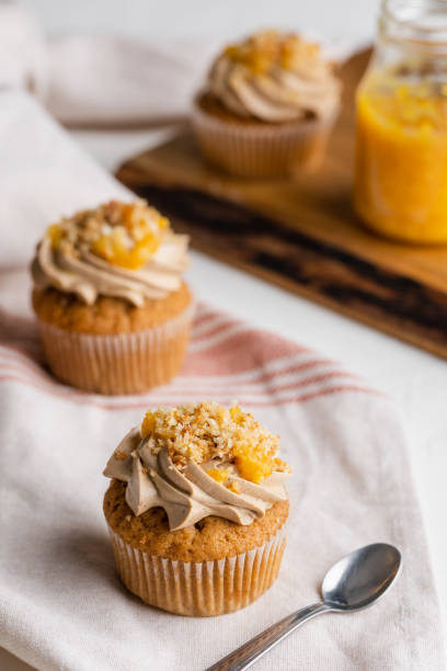 istock Selective-focus shot of a yellow marmalade cupcake on a rustic wooden table 1454344259