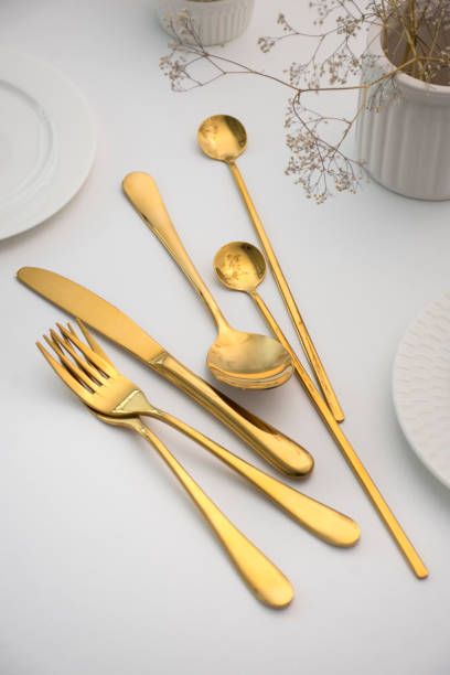 istock Golden cutlery on a white table 1454344382
