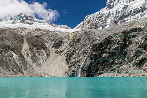 A beautiful view of a lake surrounded by rocky mountains in Huascaran National Park, Huallin, Peru