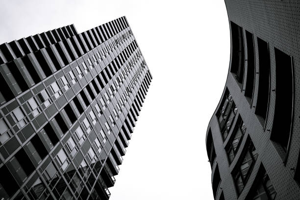 istock Low angle grayscale shot of a modern building with windows 1454346273
