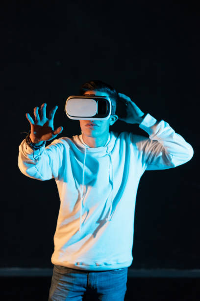 istock Young Hispanic male experiencing virtual reality for the first time on a black background 1454346528