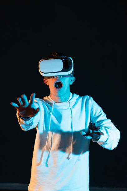 istock Young Hispanic male experiencing virtual reality for the first time on a black background 1454346553