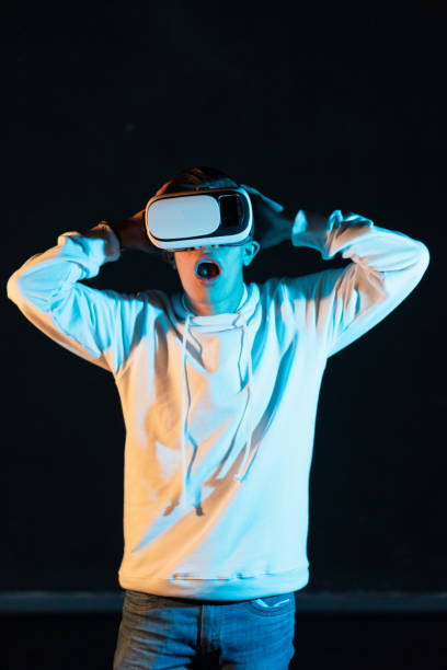 istock Young Hispanic male experiencing virtual reality for the first time on a black background 1454346561