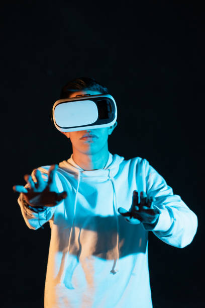 istock Young Hispanic male experiencing virtual reality for the first time on a black background 1454346565