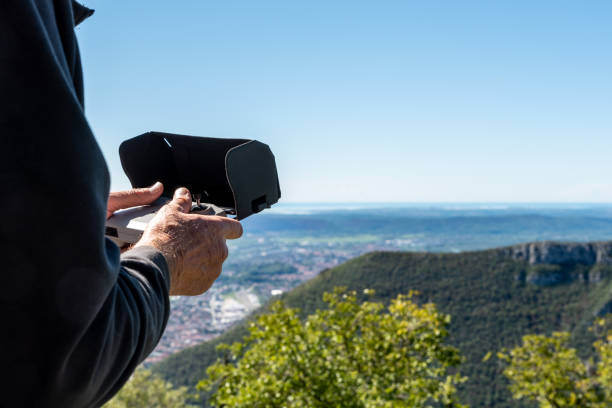 istock Man Using Remote Control to Flying a Drone for Making Landscape Videos and Photo 1454346647