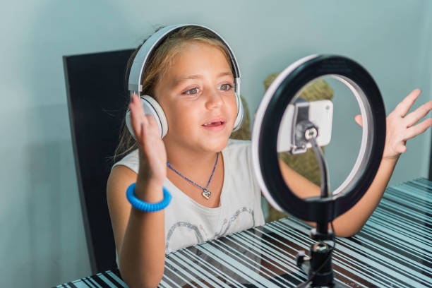 istock Little caucasian girl making a video tutorial with her mobile phone. 1454347019