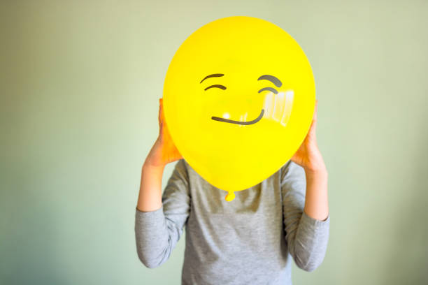 istock Child holding yellow balloon in the hands 1454348002