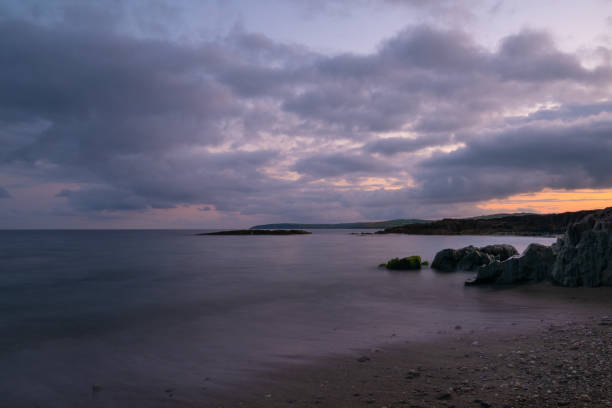 istock Beautiful view of a coast under a cloudy sunset sky 1454348026