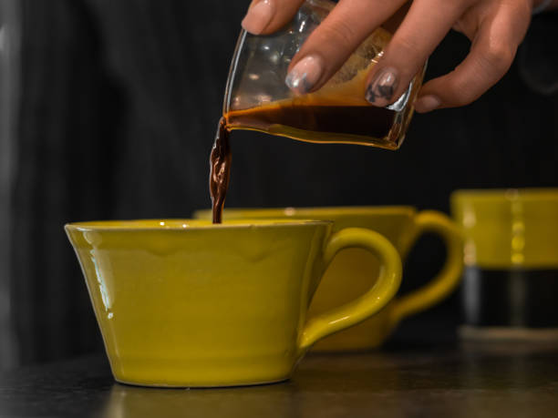 istock Hand pouring coffee in yellow cups 1454349020