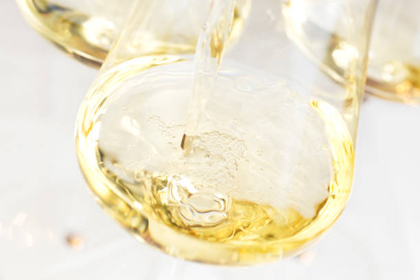 verter vino blanco en una copa con fondo brillante - wine pouring wineglass white wine fotografías e imágenes de stock